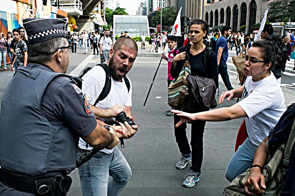 Caio Castor é violentamente impedido pelo policial militar de trabalhar durante ato público. Foto: Vinicius Gomes.